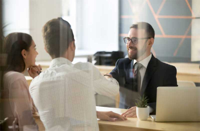 Couple shaking hands with banker
